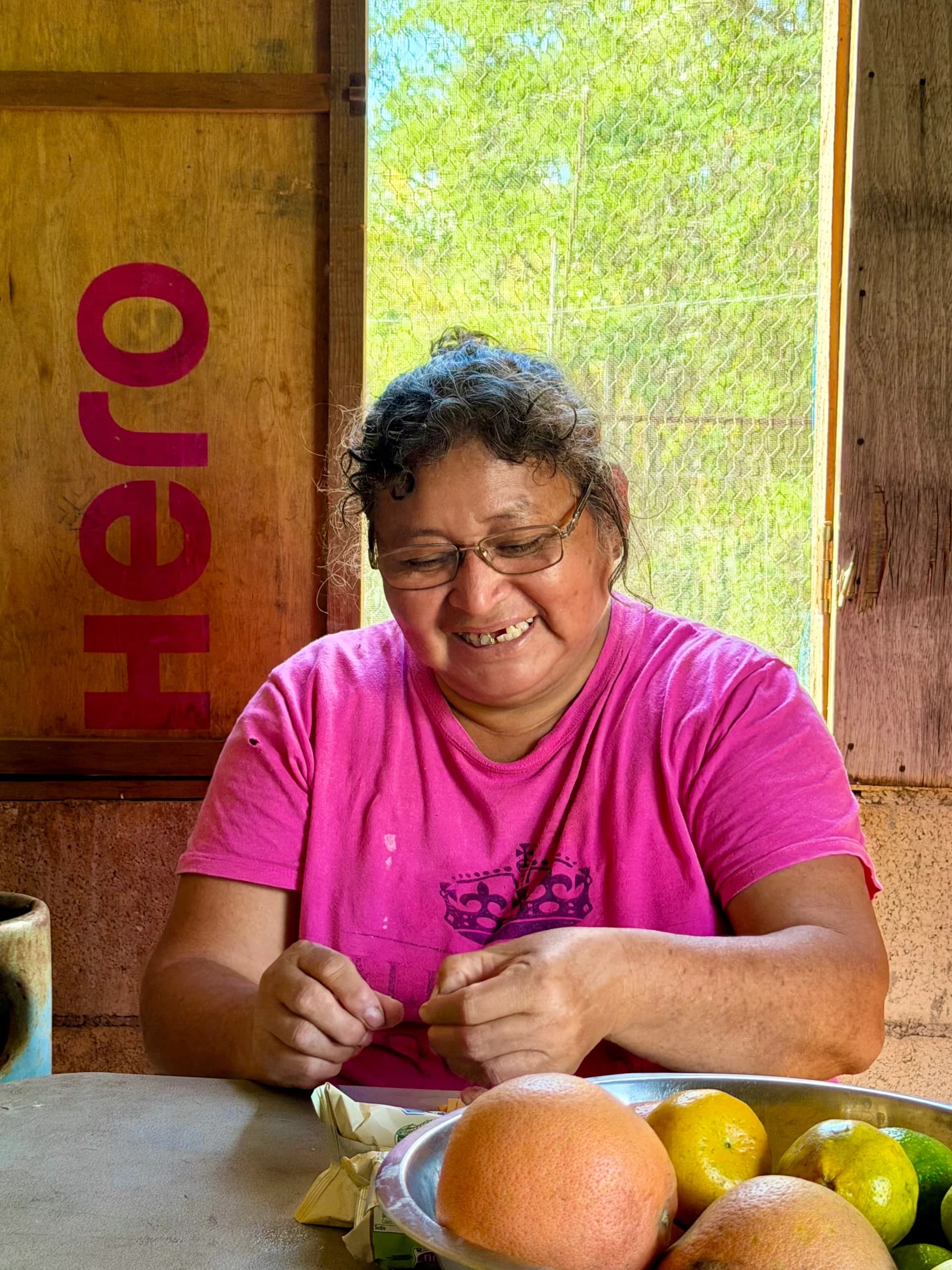 Doña Chivis sentada en la cocina de su casa junto a un plato de frutas