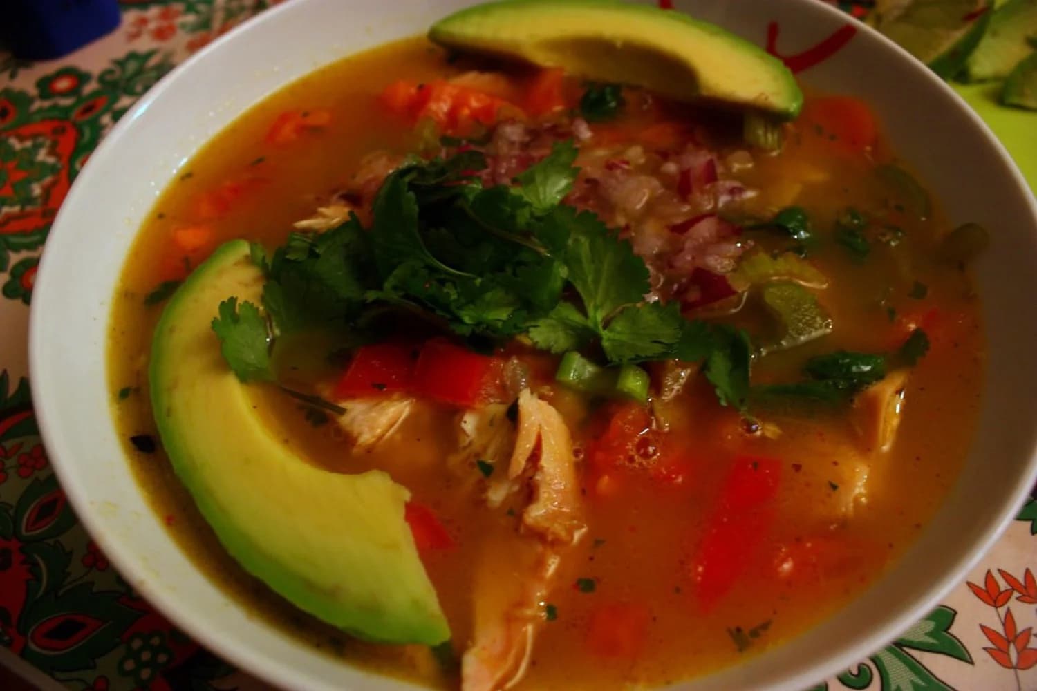 Una cocinera vierte caldo humeante en un plato hondo de barro